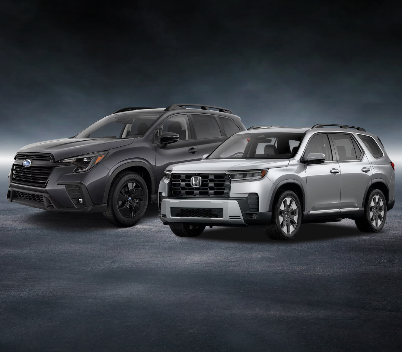 Front-three-quarter view comparing a Subaru Ascent Onyx Edition in Magnetite Gray Metallic with a Honda Pilot Elite in Solar Silver Metallic.