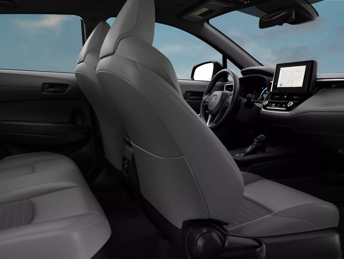 Split image of two hybrid car interiors: top shows Subaru Crosstrek's dark, leather seats; bottom features Toyota Corolla's light, fabric seats. Both have scenic backgrounds.